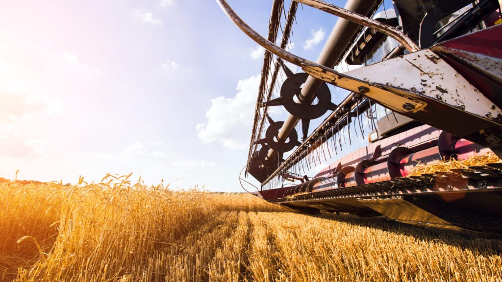 photo of combine harvester that is harvesting wheat