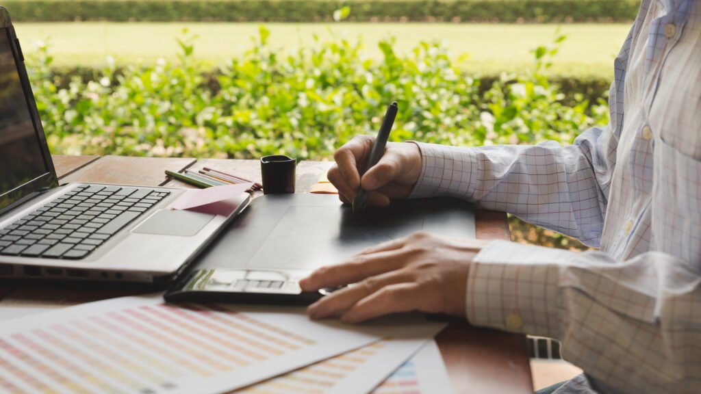freelance graphic designer using digital tablet, computer, man w