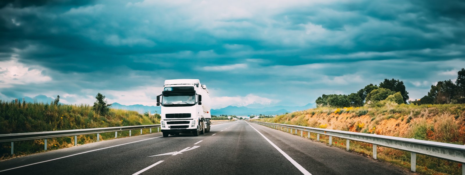 Capitalização diária: transparência na contratação do financiamento white truck or traction unit in motion on road, freeway. asphalt motorway highway against background of mountains landscape. business transportation, trucking industry
